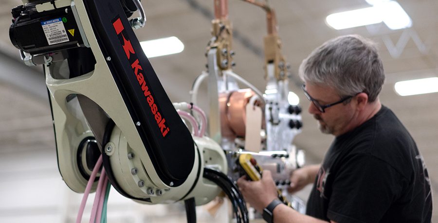 Employee works on Kawasaki robot