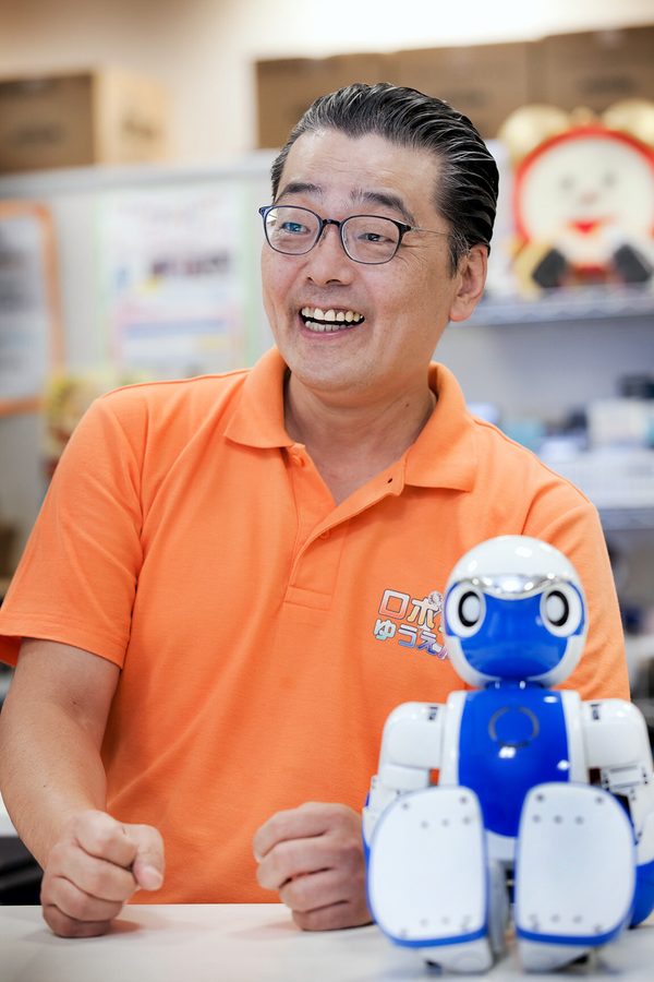 岡本氏とヒューマノイドのおもちゃのツーショット