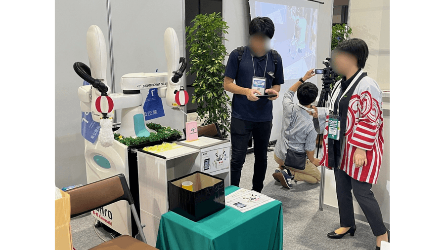 ロボットテクノロジージャパンで共同ロボットを操作する来場者